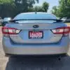 A 2018 Subaru Impreza Sport w/ Tech pkg with a LOADED license plate from Boss Auto is parked outdoors. Other cars and trees are visible under a clear sky.