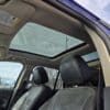 The interior of a 2013 Ford Edge SEL V6 with black leather seats is visible, highlighting a sunroof and open passenger door, with power lines and trees seen through the sunroof and rear window.