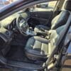 Interior view of a car showing the front seats and dashboard. The seats are leather, and the dashboard features typical controls and a steering wheel. The car door is open, allowing a clear view inside.